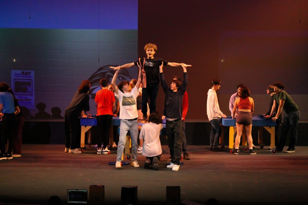 William Corwin, playing Damian Hubbard in the "Mean Girls: The Musical" performance, is gracefully lifted off a table by his fellow actors during a rehearsal, Nov. 6th, 2023.