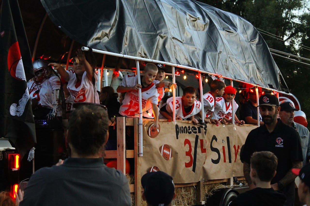 Third and fourth grade football players throw candy to homecoming parade watchers, Oct 20th 2023.