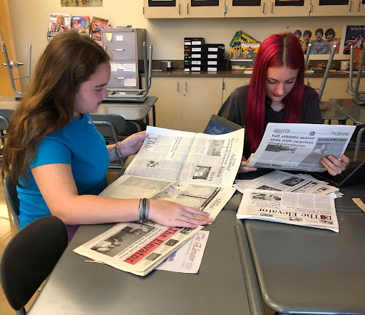 Emerie Jennings and Bliss Baxter read issues of “The Elevator” from the early 2000’s, Oct. 10th, 2023, in room B107. Today, the journalism club had their first meeting of the year. They looked at old issues of our school’s newspaper, and studied the websites of other student led newspapers, with the main goal of coming up with ideas to improve The Elevator and its website.