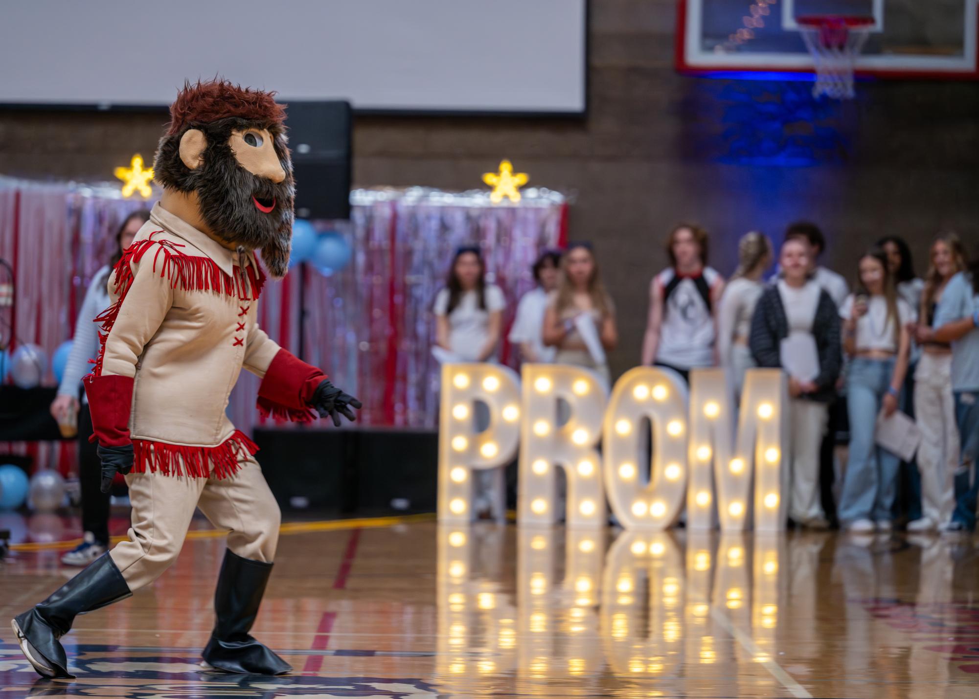 The Oregon City High School (OCHS) mascot, Pioneer Pete, engages students at the annual prom assembly, Friday, April 5. 2024. Hosted annually, this year's prom was held at NW Events & Environments in Hillsboro, Oregon. Photo Source Flickr