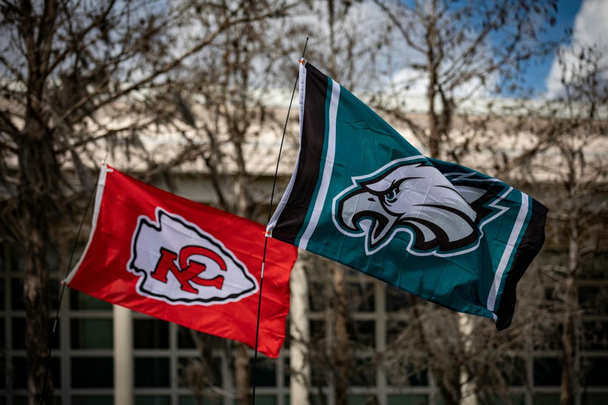 In the photo there is a Kansas City Chief's flag on the left and a Philadelphia Eagles flag on the right. At the 59th NFL Super Bowl Kendrick Lamar performed at the Apple Music Halftime Show. via Unsplash.com