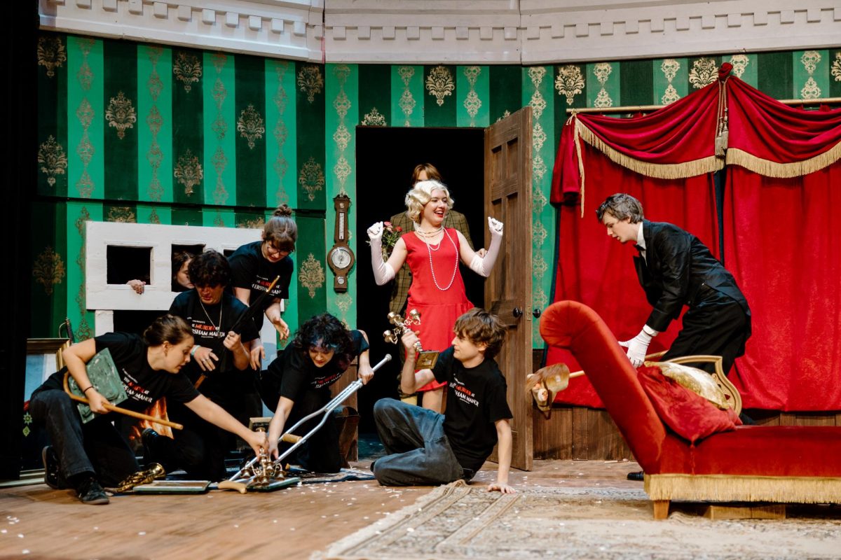 Catastrophe ensues in this moment of The Play That Goes Wrong, as the stagehands were embodying the broken mantel piece, Aeva Dahlin (playing Sandra) burst into the scene, knocking over the balancing act they had set up. As the crew struggles to get everything out of the way, the actors must keep on through the scene as though nothing happened.