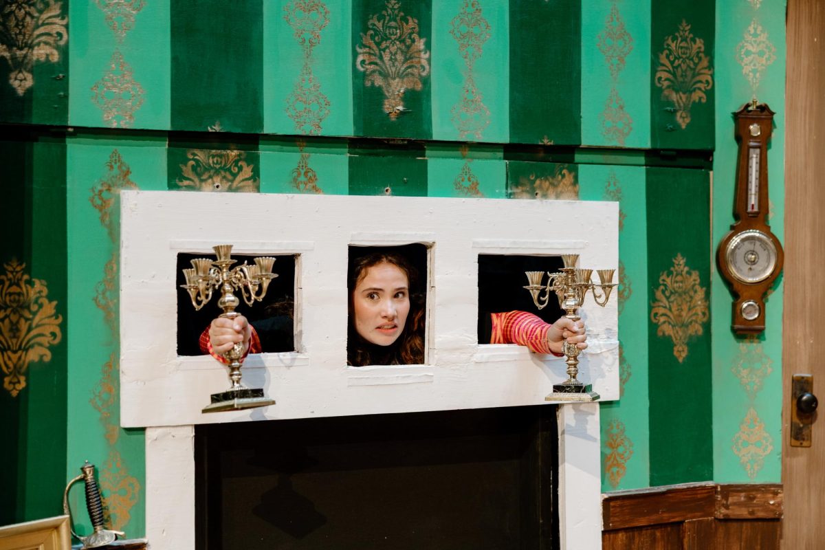 Here we have Cambria Rich, a senior at OCHS, playing the role of Annie, the stage manager, in The Play That Goes Wrong. Rich’s character got her big break in this scene as she tore through the wall to fill in for the missing mantel piece. Rich has been doing theatre since she was young, and has been participating throughout her life in both plays and musicals.