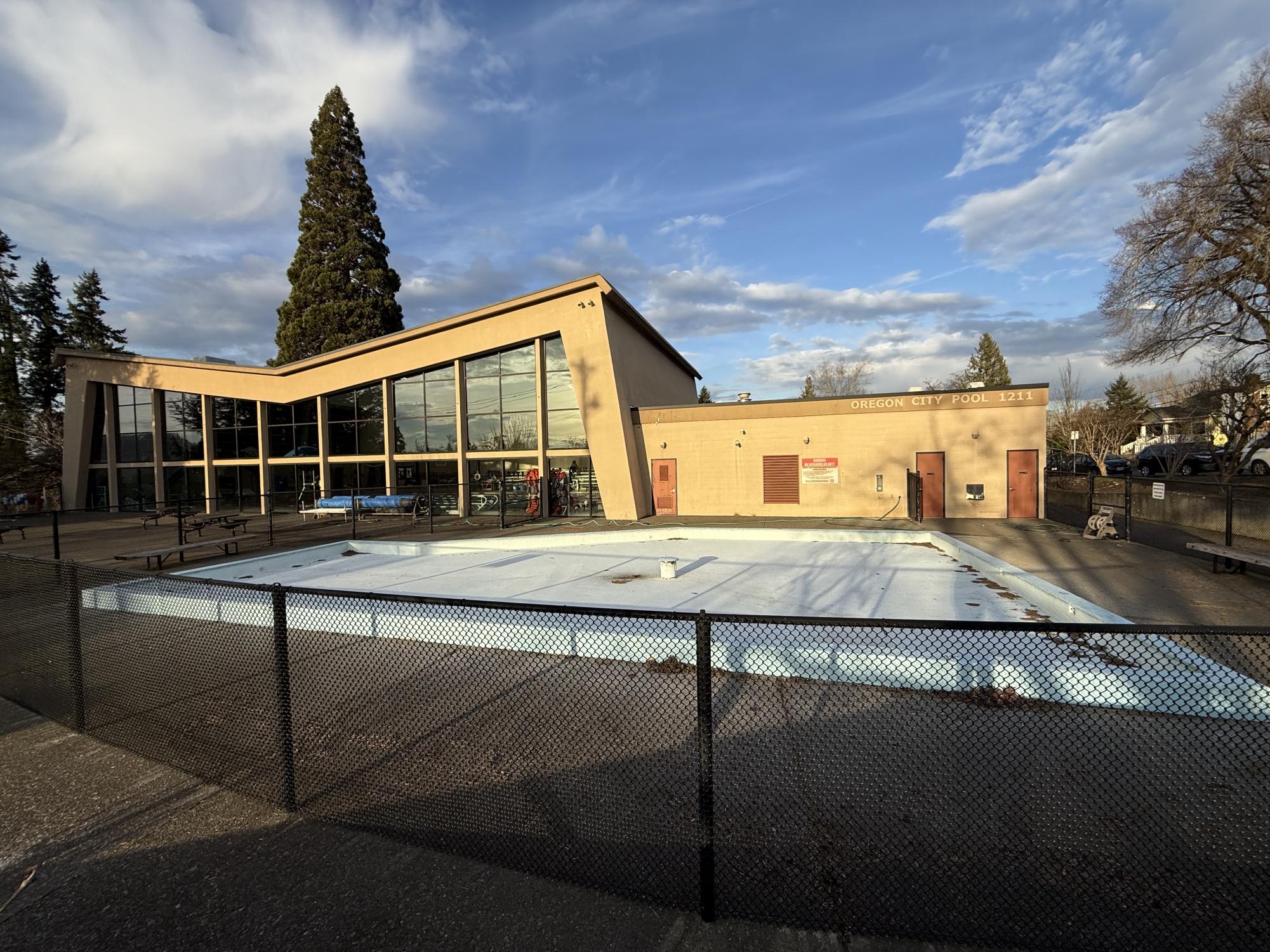 Swimming pool is being used by some people. The small outdoor swimming pool is unoccupied and has no water in it. The Oregon City Swimming Pool is hosting it's 60th birthday.