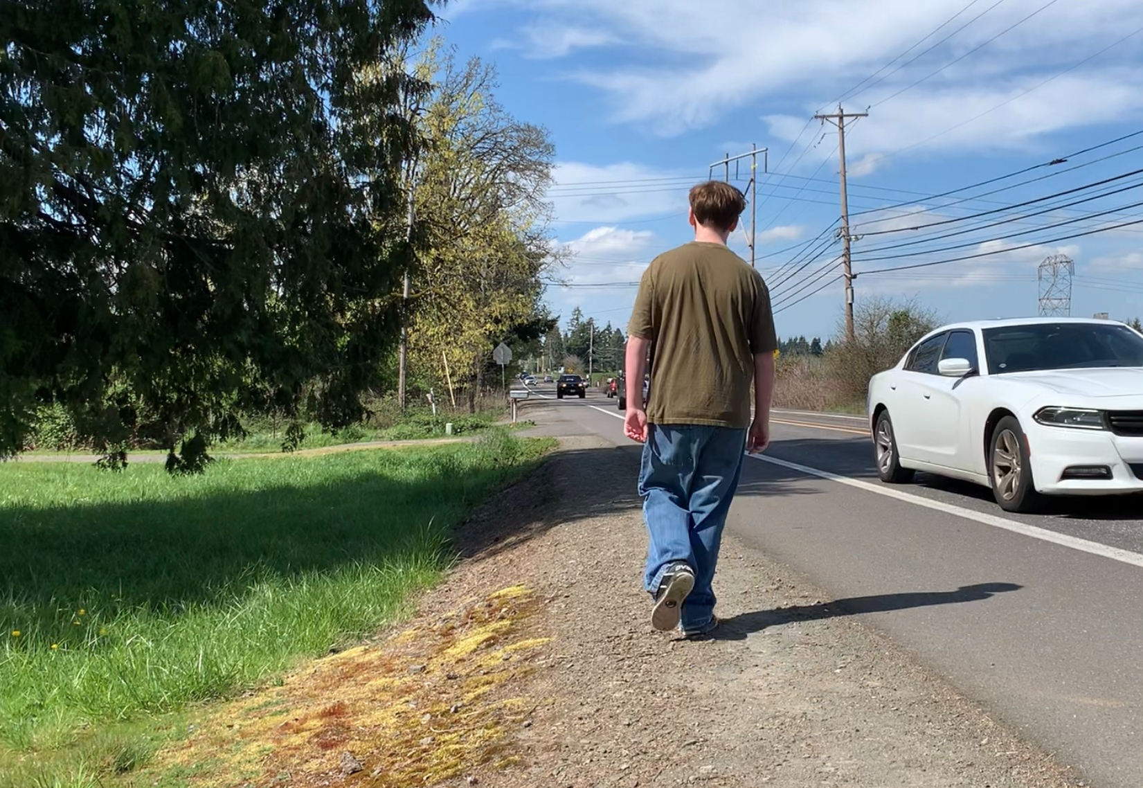 An OCHS student walks on the narrow shoulder of Beavercreek road